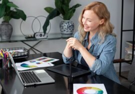 Woman designing custom printed marketing materials on a laptop and graphics tablet